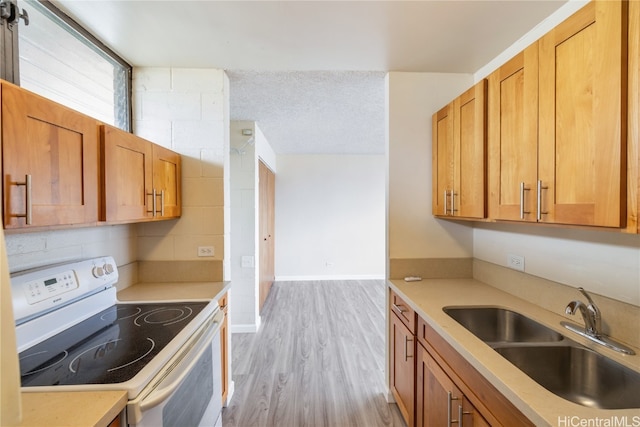 kitchen featuring electric range, sink, a textured ceiling, decorative backsplash, and light wood-type flooring