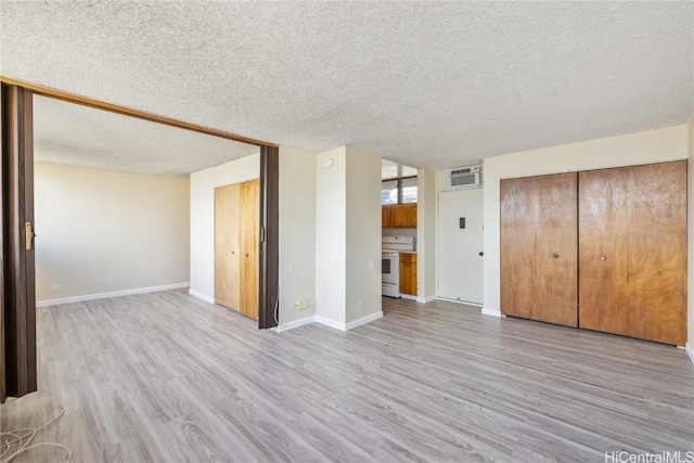 unfurnished living room featuring a textured ceiling and light hardwood / wood-style floors