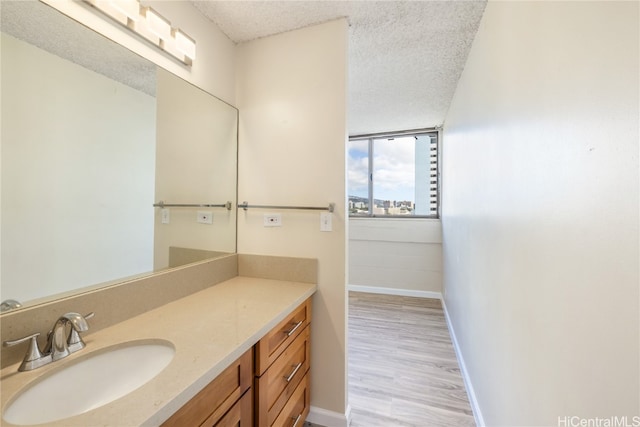 bathroom featuring vanity, wood-type flooring, and a textured ceiling