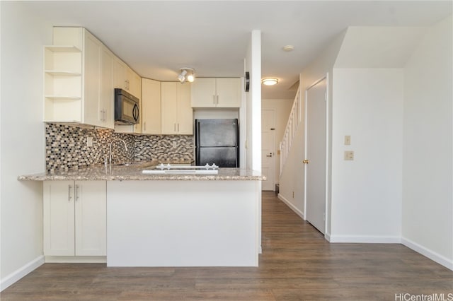 kitchen featuring black appliances, light stone countertops, kitchen peninsula, and dark wood-type flooring