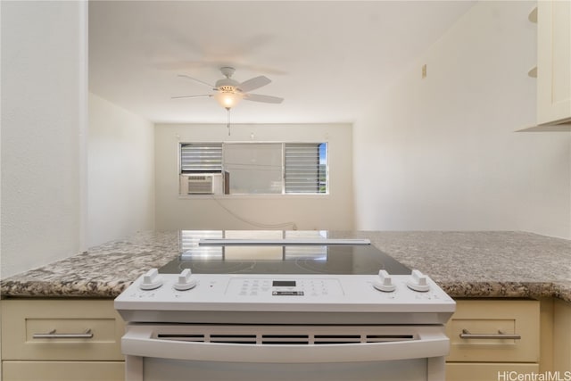 kitchen with cream cabinetry, white range, cooling unit, and ceiling fan