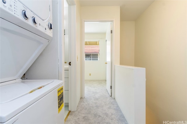 clothes washing area with washer / dryer and light carpet