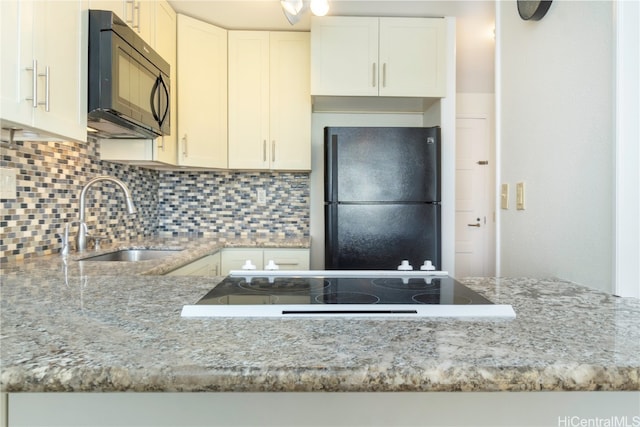 kitchen with light stone countertops, sink, white cabinetry, and black appliances