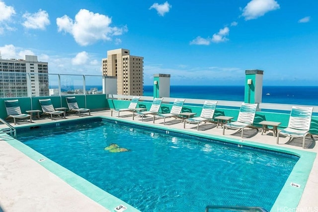 view of pool featuring a patio and a water view