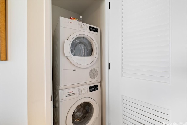 clothes washing area with stacked washer and clothes dryer