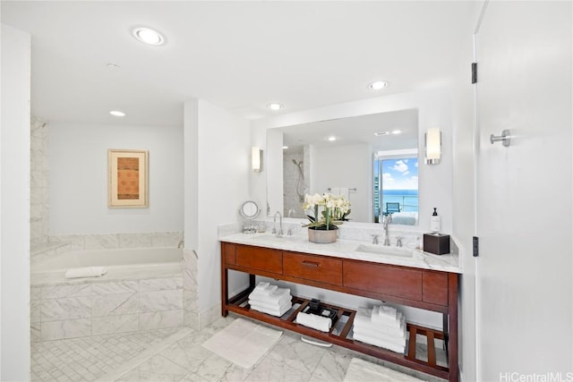 bathroom with vanity and tiled bath