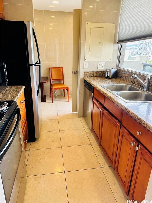 444 Nahua St Unit 2211, Honolulu, HI 96815 - kitchen featuring a sink, stainless steel appliances, tile walls, brown cabinets, and light tile patterned flooring