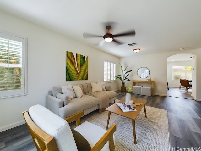 living room featuring ceiling fan, a healthy amount of sunlight, and dark hardwood / wood-style flooring