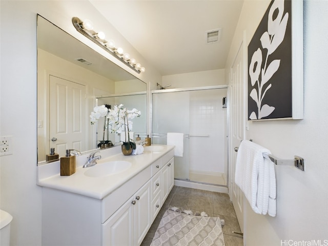 bathroom featuring tile patterned flooring, vanity, and a shower with door