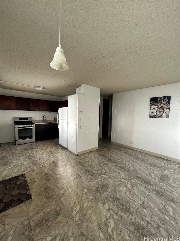 interior space with pendant lighting, stainless steel stove, white fridge, and sink