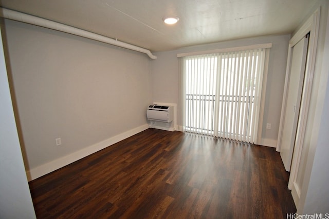 spare room with dark hardwood / wood-style flooring and a wall mounted AC