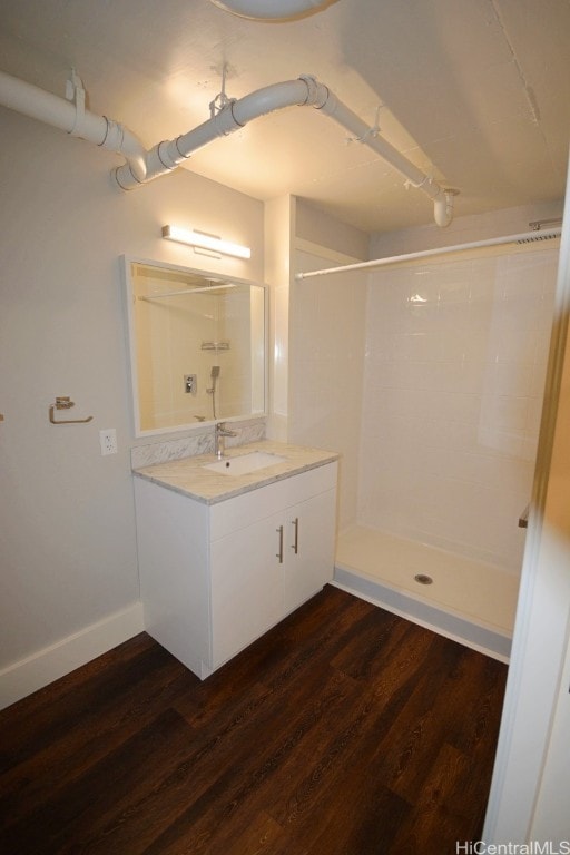 bathroom with hardwood / wood-style flooring, vanity, and walk in shower