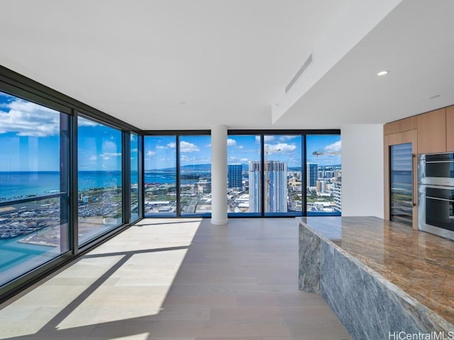 kitchen with a wall of windows, a healthy amount of sunlight, and stainless steel double oven