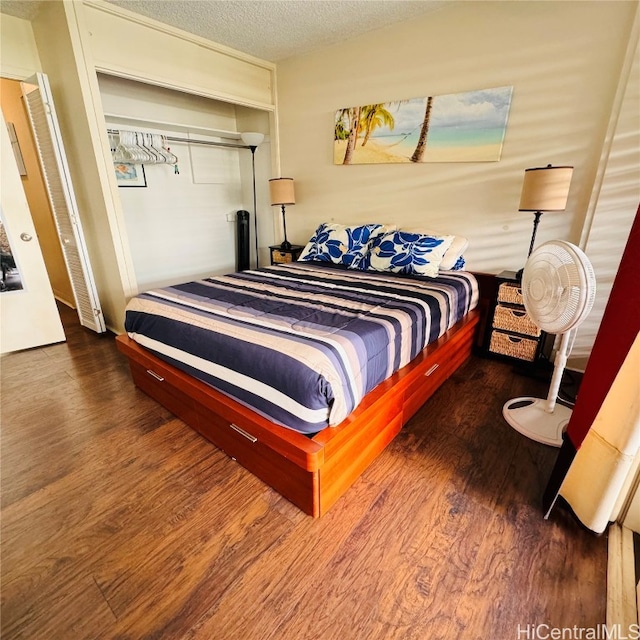 bedroom featuring a closet, hardwood / wood-style floors, and a textured ceiling