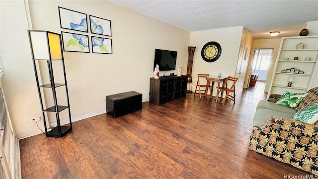 living room with dark wood-type flooring and a textured ceiling