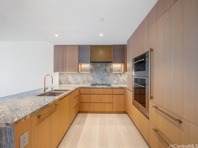 kitchen featuring backsplash, sink, light brown cabinetry, light hardwood / wood-style floors, and stainless steel appliances