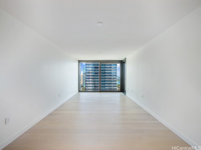 unfurnished room featuring expansive windows and light hardwood / wood-style floors