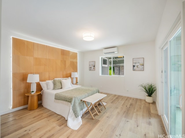 bedroom with light wood-type flooring and a wall mounted AC