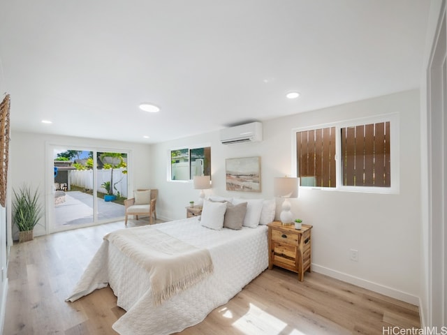 bedroom with access to exterior, a wall mounted AC, and light wood-type flooring