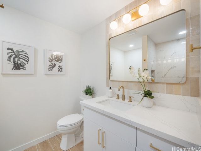 bathroom featuring tiled shower, hardwood / wood-style floors, vanity, and toilet