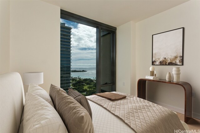 bedroom with a water view and a wall of windows