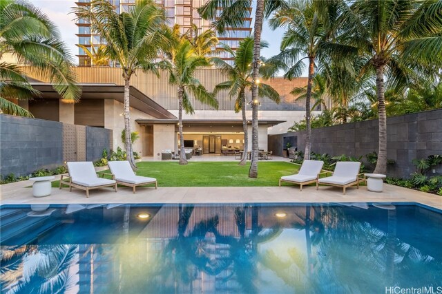 view of pool with a patio area and a yard