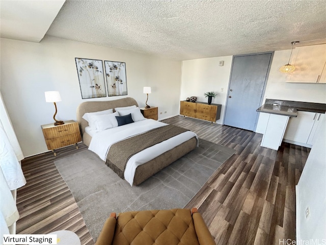 bedroom with a textured ceiling and dark wood-type flooring