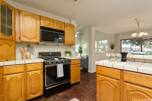 kitchen with dark parquet flooring, tile counters, black appliances, and lofted ceiling