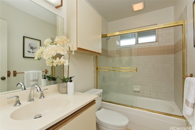 full bathroom featuring vanity, toilet, and bath / shower combo with glass door