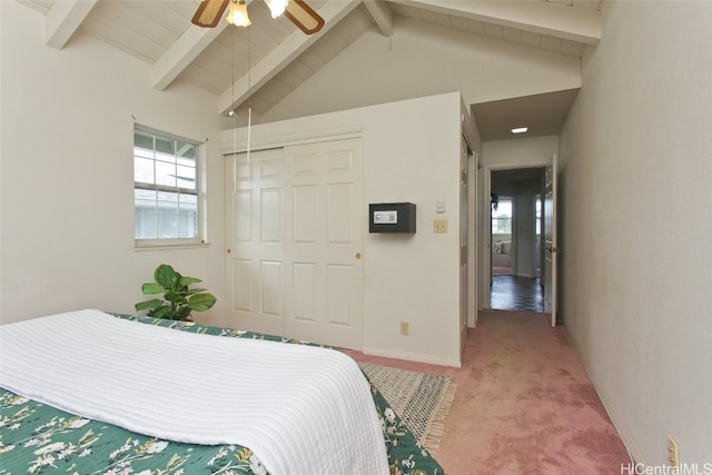 bedroom with carpet flooring, vaulted ceiling with beams, ceiling fan, and a closet