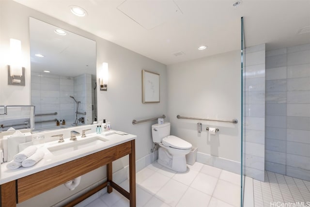 bathroom featuring tile patterned flooring, toilet, a tile shower, and sink