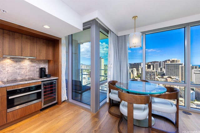 2139 Kuhio Ave Unit D2908, Honolulu, HI 96815 - dining area with wine cooler, light wood finished floors, a city view, a wall of windows, and a dry bar