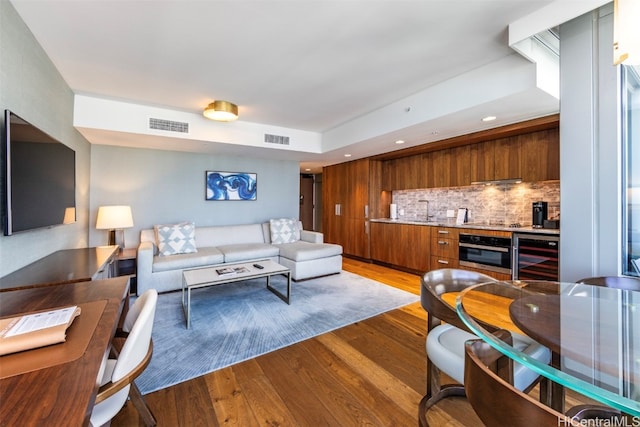 living room with hardwood / wood-style floors and beverage cooler