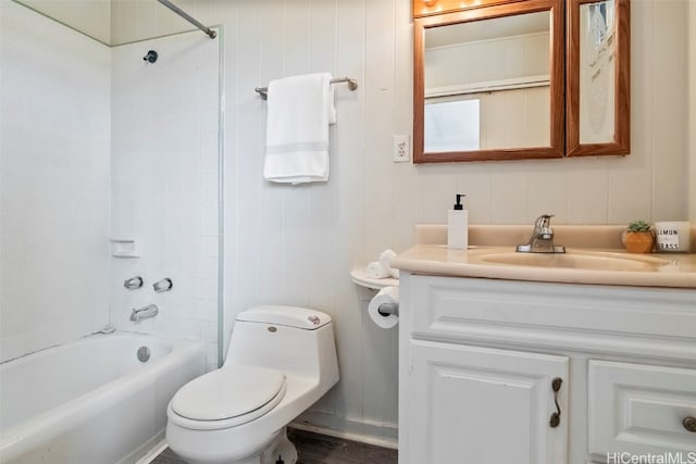 full bathroom with hardwood / wood-style flooring, vanity, tiled shower / bath combo, and toilet