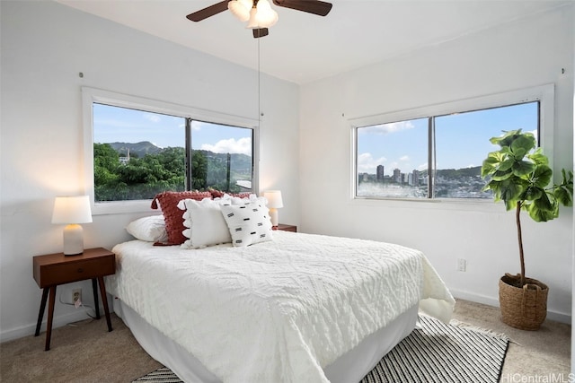 carpeted bedroom with multiple windows and ceiling fan