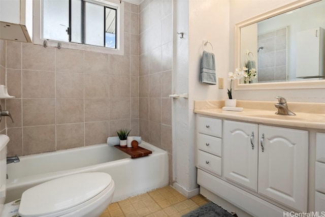 full bathroom with tile patterned floors, vanity, tiled shower / bath combo, and toilet