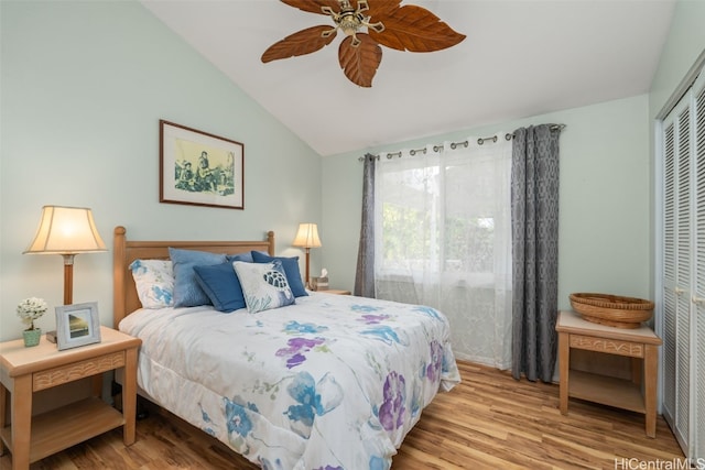 bedroom with a closet, lofted ceiling, wood finished floors, and a ceiling fan