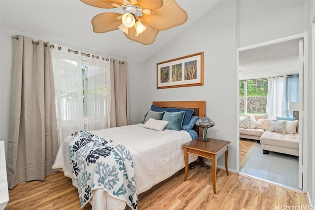 bedroom with vaulted ceiling, a ceiling fan, and wood finished floors