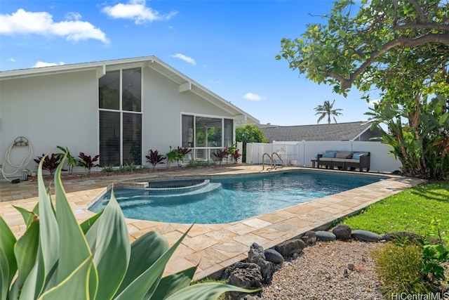 view of swimming pool with a patio area, fence, and a pool with connected hot tub