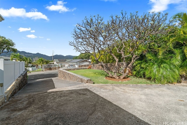 view of yard featuring fence and a mountain view