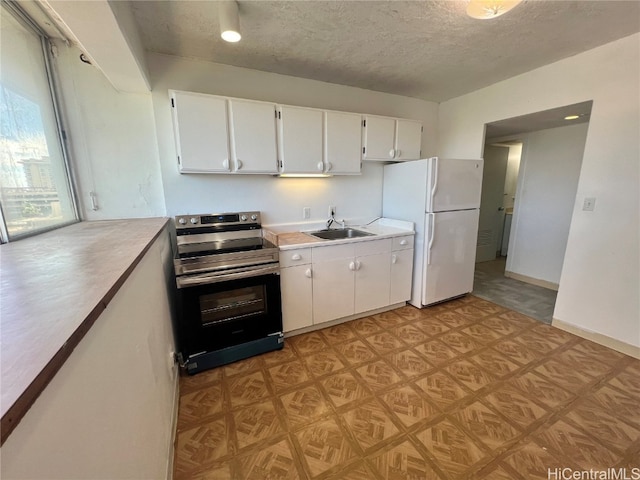 kitchen featuring white cabinetry, sink, white refrigerator, a textured ceiling, and stainless steel electric stove