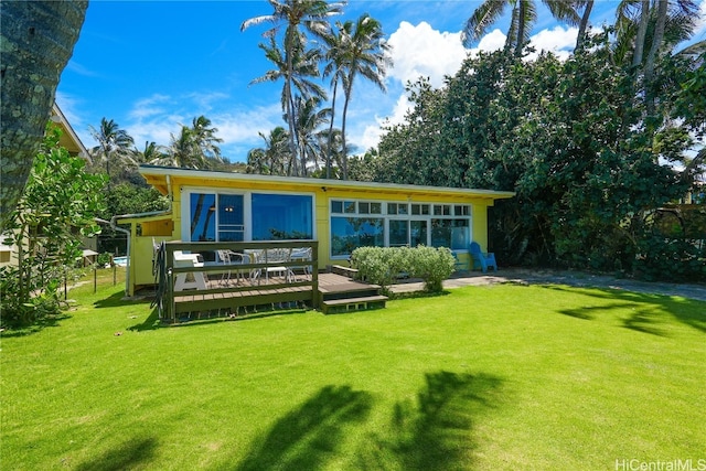 back of house with a lawn and a deck