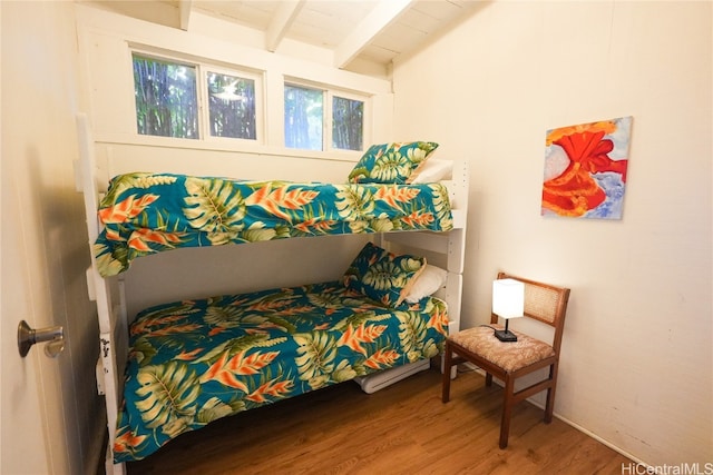 bedroom featuring beamed ceiling and hardwood / wood-style flooring