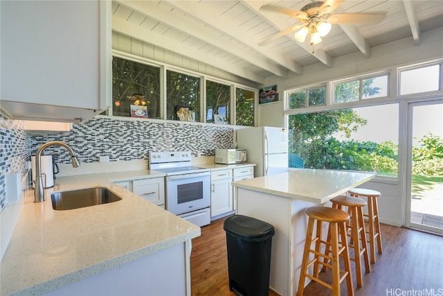 kitchen featuring white cabinetry, sink, a healthy amount of sunlight, and white appliances