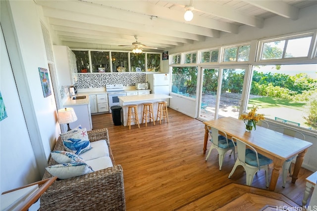 sunroom featuring beamed ceiling and ceiling fan