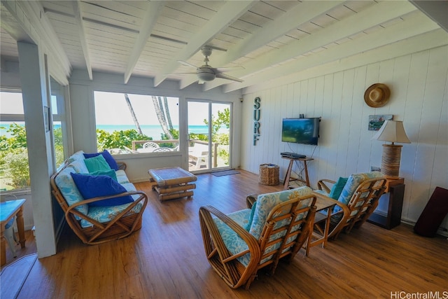 sunroom / solarium featuring ceiling fan and beamed ceiling