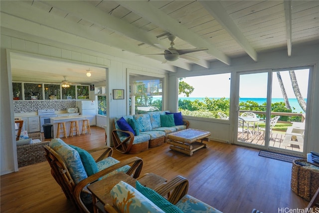 sunroom / solarium featuring ceiling fan, beam ceiling, and a water view