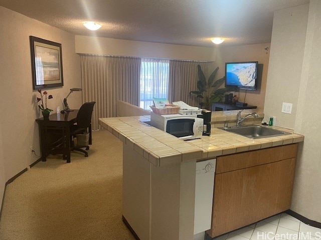 kitchen with tile countertops, white appliances, light carpet, sink, and kitchen peninsula