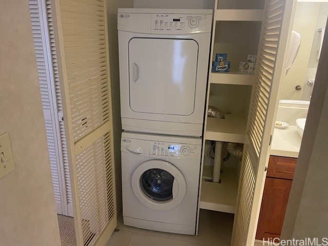 washroom featuring light tile patterned flooring and stacked washer / drying machine