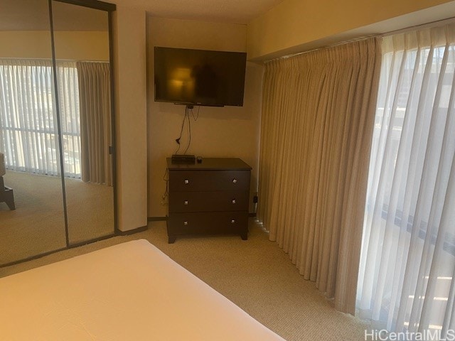 bedroom with light colored carpet and a closet